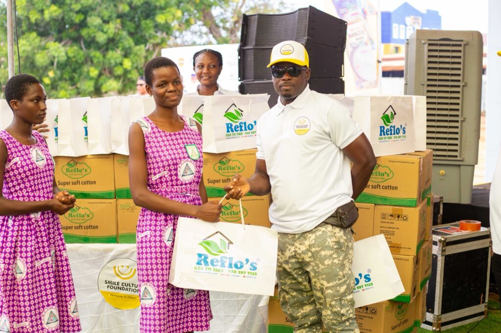 A student receives sanitary pads and essentials from an official
